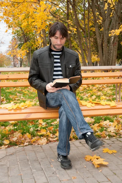 Homme d'âge moyen avec un livre dans le parc d'automne — Photo