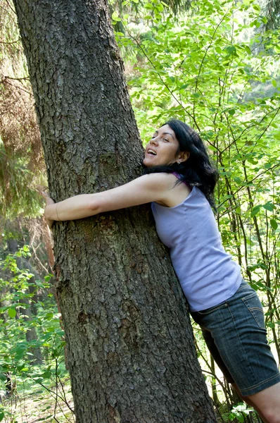 Eine schöne Frau mittleren Alters in einem Wald nahe einem alten Baum — Stockfoto