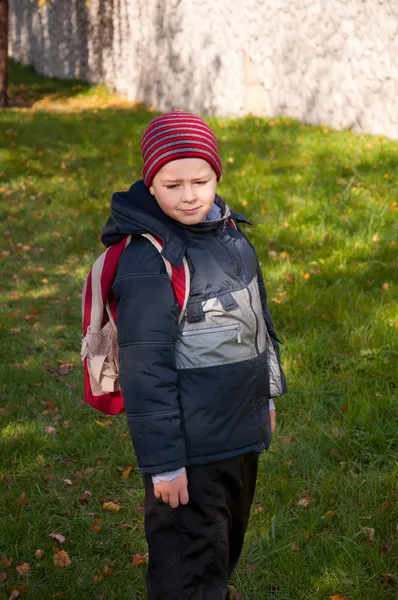 一个男孩与一个背包在秋季城市公园 — 图库照片