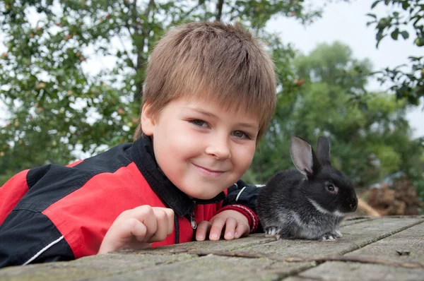 stock image A boy with a rabbit in the garden on a summer residence