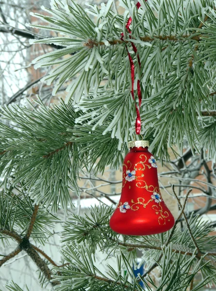 Eine schöne rote Weihnachtsdekoration auf einem verschneiten Weihnachtsbaum — Stockfoto