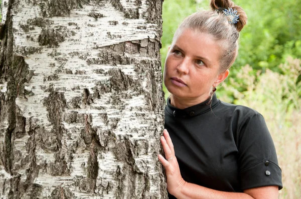 Російський middleaged жінка стоїть берези — стокове фото