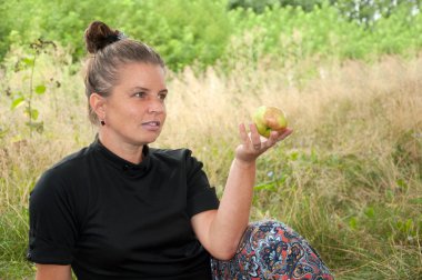 Orta yaşlı bir kadın elma elinde