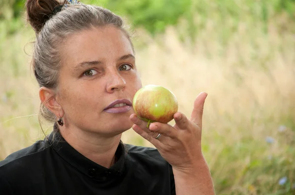 Femme d'âge moyen avec une pomme à la main — Photo