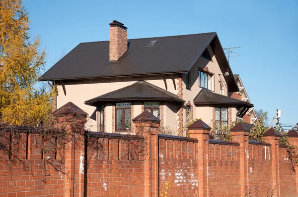 Dwupiętrowy domek z czerwonej cegły z ogrodzenia — Zdjęcie stockowe