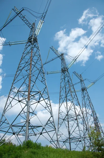 Poteaux de transmission de puissance contre le ciel bleu d'été — Photo