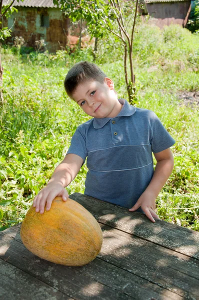 Jongen met een grote meloen in zijn hand, oogst — Stockfoto