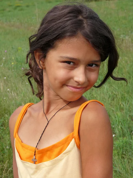 一个黑头发的女孩在草地上的肖像 — 图库照片