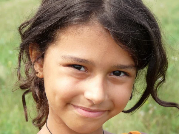Retrato de uma menina de cabelos escuros em um prado — Fotografia de Stock