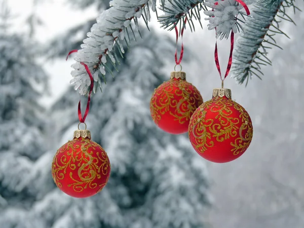 Рождественские шары на заснеженной ели — стоковое фото