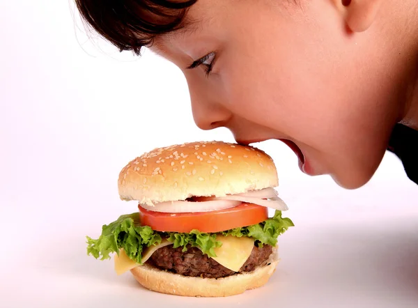 Junge isst Hamburger — Stockfoto