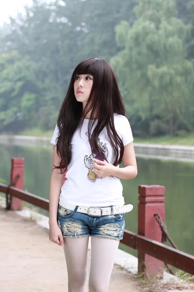 Una bella donna asiatica in un parco . — Foto Stock
