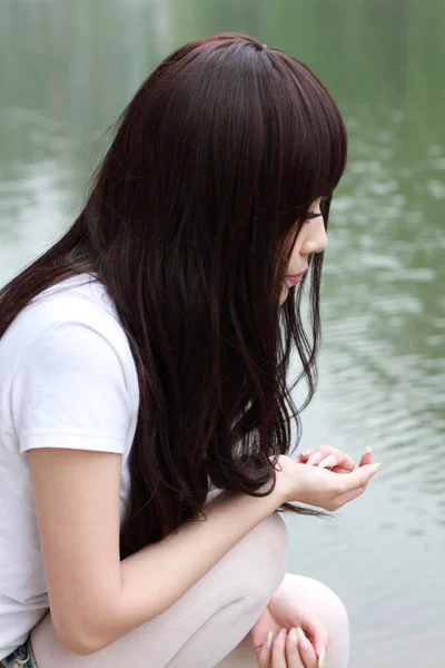 Egy gyönyörű ázsiai nő, egy parkban. — Stock Fotó