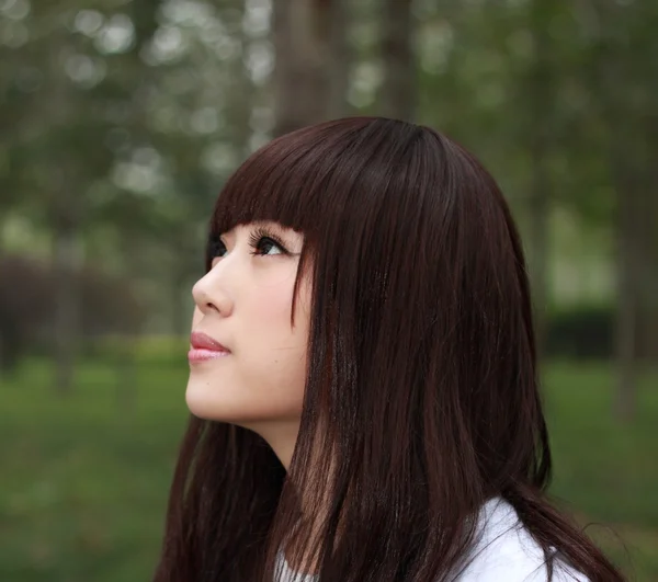 Een mooie Aziatische vrouw in een park. — Stockfoto