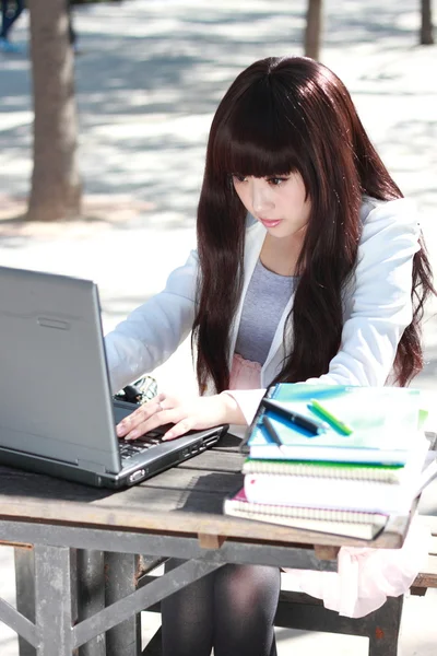 Una estudiante asiática sonriente está estudiando . —  Fotos de Stock