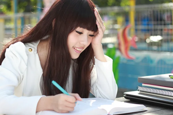 Улыбающийся азиатский студент учится . — стоковое фото