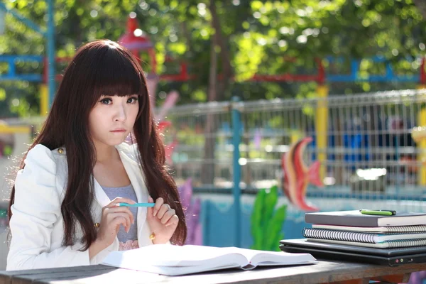 Улыбающийся азиатский студент учится . — стоковое фото