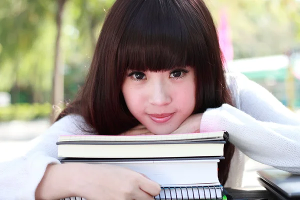 Una estudiante asiática sonriente está estudiando . Imagen de stock