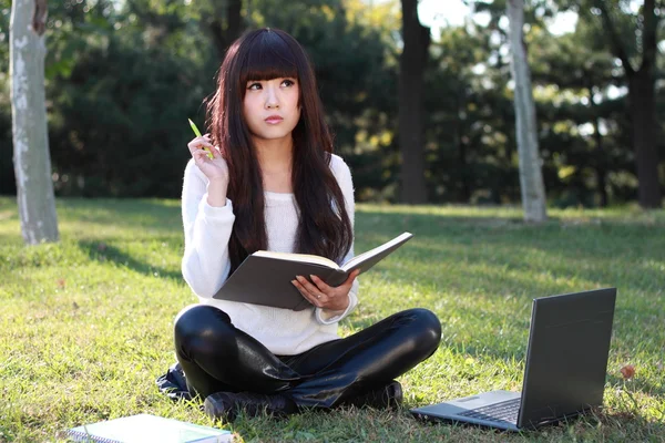 Una estudiante asiática sonriente está estudiando . — Foto de Stock