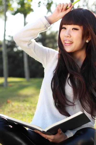 Una estudiante asiática sonriente está estudiando . — Foto de Stock