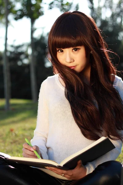Usměvavá asijská studentka studuje. — Stock fotografie