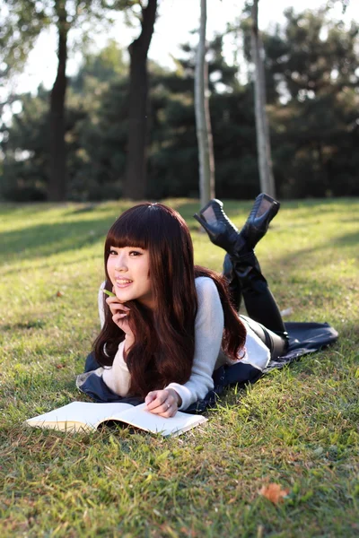 Gülümseyen bir Asya öğrenci okuyor. — Stok fotoğraf