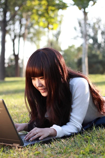 Um estudante asiático sorridente está estudando . — Fotografia de Stock