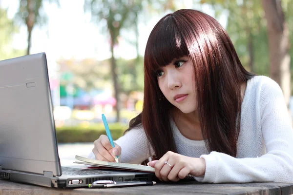 Um estudante asiático sorridente está estudando . Imagem De Stock