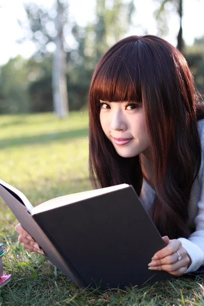 Gülümseyen bir Asya öğrenci okuyor. — Stok fotoğraf
