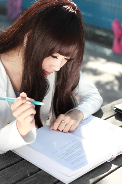 Ein lächelnder asiatischer Student studiert. Stockbild