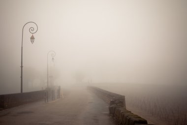 Foggy road with old lamps clipart