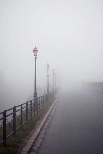 Туманная дорога со старыми лампами — стоковое фото