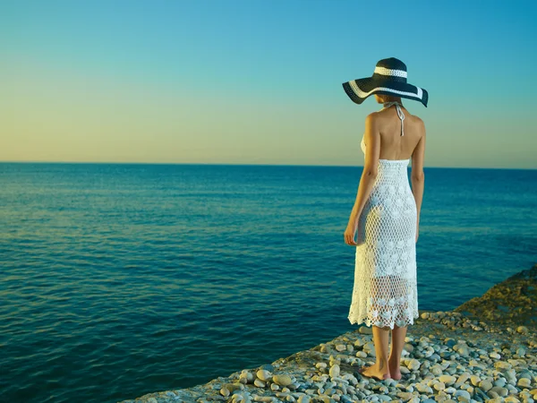 Элегантная женщина в шляпе на море — стоковое фото
