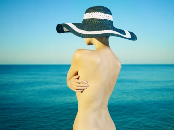 Γυμνό κομψή γυναίκα σε ένα καπέλο στη θάλασσα — Φωτογραφία Αρχείου