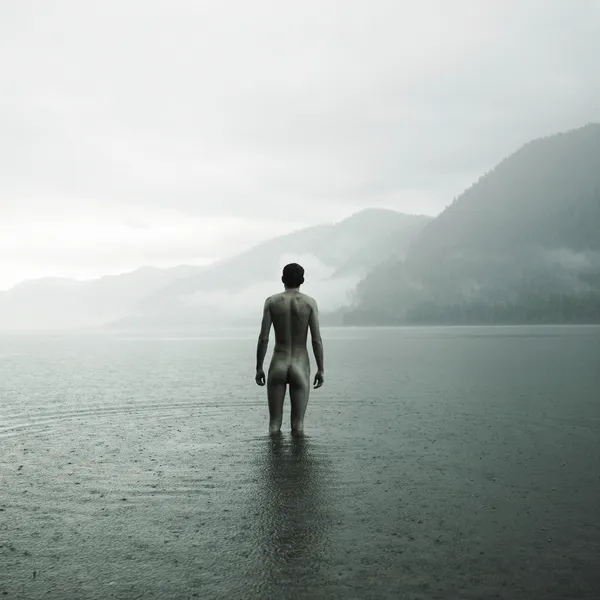 Молодой голый мужчина в озере — стоковое фото