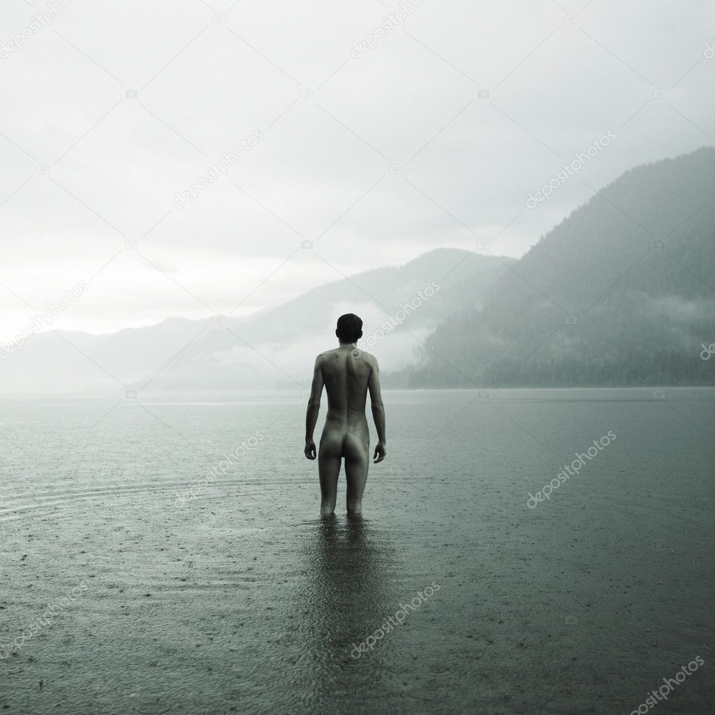Young naked man in lake