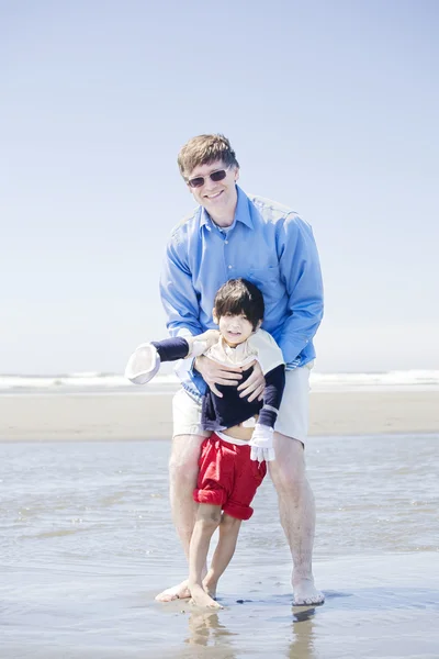 Apa gyalog fogyatékos fia a strandon — Stock Fotó