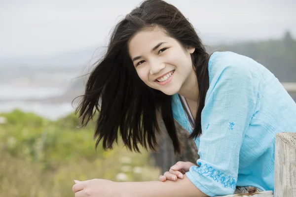 Preteen biracial dziewczyna z pięknym uśmiechem, z widokiem na brzeg oceanu — Zdjęcie stockowe