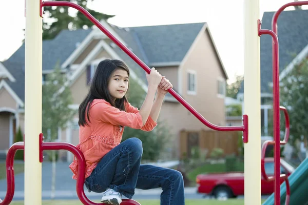 Nine year old girl playing on the bars at playground — Stock Photo, Image
