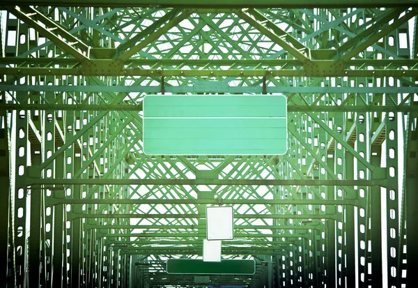Зеленый дорожный знак на зеленом мосту абстрактными рисунками — стоковое фото