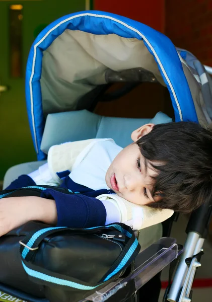 Deficiente menino de cinco anos em cadeira de rodas esperando na escola — Fotografia de Stock