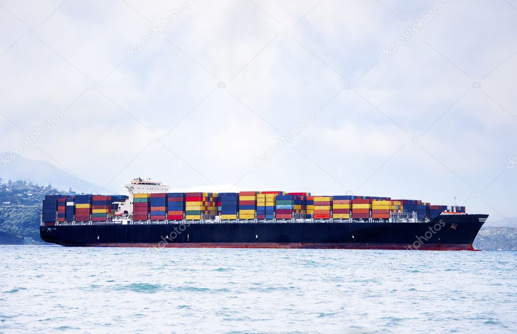 Large cargo ship in water carrying colorful shipping containers