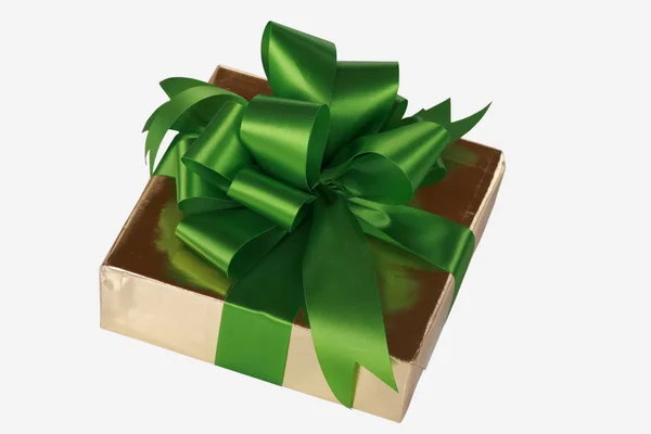 Золотий подарунок, загорнутий зеленими стрічками — стокове фото