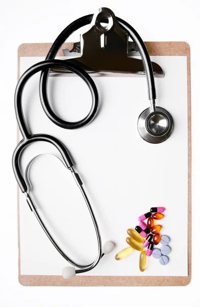 Stethoscope and medicine on clipboard — Stock Photo, Image