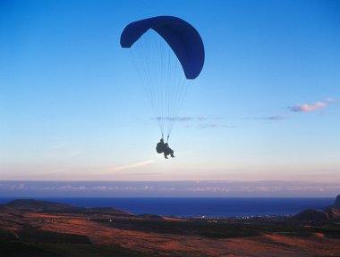 Tandem paragliding at sunset. clipart