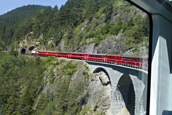 Glacier express kör över en viadukt in i en tunnel — Stockfoto