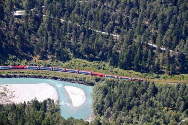 Train Glacier Express drives alongside river Rhine in canyon clipart