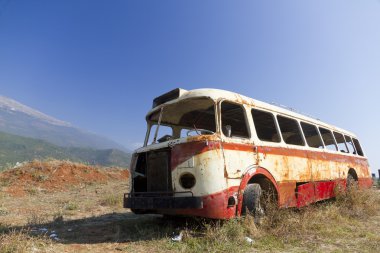 Bus wreck in arid landscape clipart