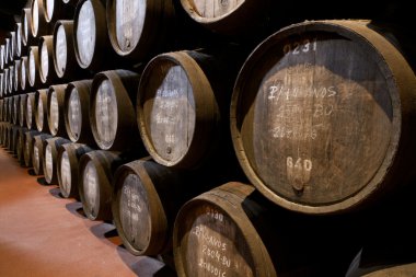 Port wine ages in barrels in cellar clipart