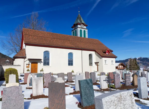 Cementerio con una pequeña iglesia en un día soleado de invierno —  Fotos de Stock